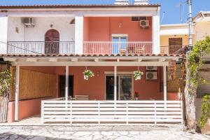a house with a white fence in front of it at Τrilogy Studios in Syvota