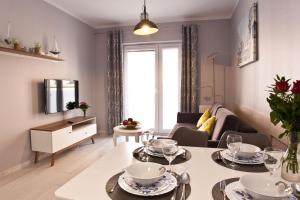 a living room with a table with plates and glasses on it at Apartament Toscania in Kołobrzeg