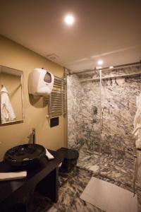 a bathroom with a sink and a glass shower at Juliet Rooms & Kitchen in Istanbul