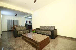 a living room with two couches and a coffee table at Tranquil orchid serviced Apartment in Bangalore