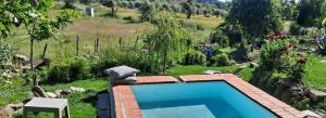 una piscina en medio de un jardín en CASA DA VIZINHA, QUINTA DAS MEMÓRIAS, en Santo António das Areias