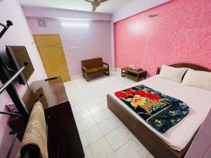 a bedroom with a bed and a pink wall at Hotel Green Land in Bāndarban