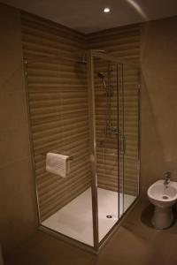 a glass shower in a bathroom with a toilet at Casa do Sapateiro in Ferrel