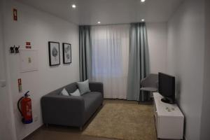 a living room with a couch and a television at Casa do Sapateiro in Ferrel