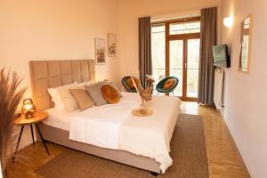 a bedroom with a large bed with two chairs at Hotel Hofgut Imsbach Lapointe in Tholey