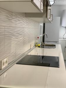 a kitchen with white counters and a sink at Apartamento Garbinet in Alicante