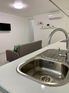 a kitchen counter with a sink and a couch at Apartamento Garbinet in Alicante
