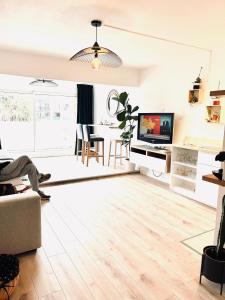 a living room with a couch and a tv at Le sud plage et piscine in Gassin