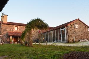 Touro的住宿－Fogar de Insua，院子里有树的砖砌建筑
