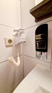 a bathroom with a toilet paper dispenser on the wall at Hotel Zentrum in Hannover