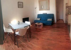 sala de estar con mesa y sofá azul en Appartement de charme avec parking et terrasse, en Besançon