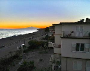 een uitzicht op een strand bij zonsondergang vanuit een gebouw bij Villa Tripepi in Bova Marina