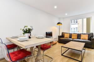 a living room with a table and a couch at Paddington Gardens in London