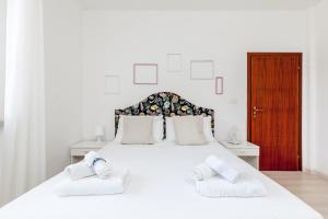 ein Schlafzimmer mit einem weißen Bett mit zwei Handtüchern darauf in der Unterkunft [LIDO DI FERMO-FREE PARKING] Appartamento miramare in Lido di Fermo