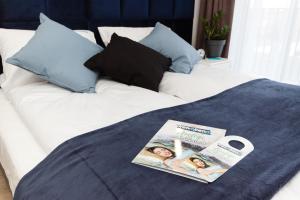 un letto bianco con una rivista sopra di Dream Team Industria a Bydgoszcz
