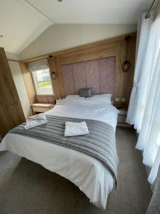 Port SetonにあるSeton sands holiday park - Premium caravan - 2 bedroom sleeps 4のベッドルーム1室(大型ベッド1台、タオル2枚付)