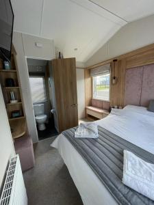 a bedroom with a large bed and a toilet at Seton sands holiday park - Premium caravan - 2 bedroom sleeps 4 in Port Seton