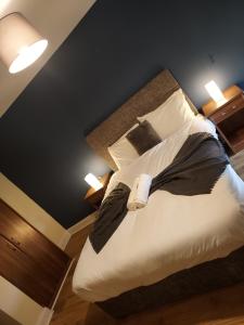 een slaapkamer met een groot bed met witte lakens en kussens bij Shannon Oaks Apartments in Portumna