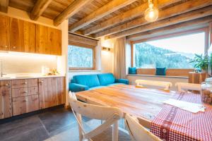 una cucina e una sala da pranzo con tavolo in legno di Chalet Noèr a Ledro
