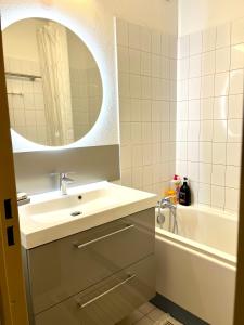 ein Badezimmer mit Waschbecken, Spiegel und Badewanne in der Unterkunft Le sud plage et piscine in Gassin + 36 Fotos