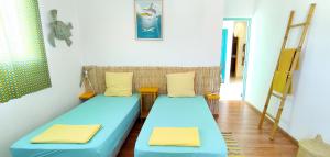 a room with two blue beds and a ladder at Ô PasSage - Kaz Auberge in Saint-Pierre