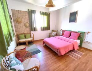 a bedroom with a pink bed and chairs in it at Ô PasSage - Kaz Auberge in Saint-Pierre