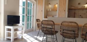 a kitchen with chairs and a tv on a counter at T2 Apartment Old Village Vilamoura in Vilamoura