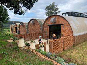 a brick building with two women standing in a garden at The Old Mushroom Farm in Howick +61 photos