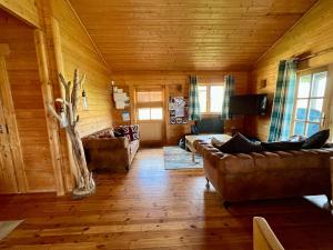 ein Wohnzimmer mit 2 Sofas und einem TV in der Unterkunft Heron Lodge, Lake Pochard in South Cerney