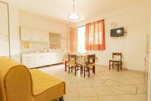 una cucina e una sala da pranzo con tavolo e sedie di Casa vacanze Nonna Nella a Porto Cesareo