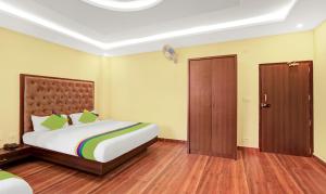 a bedroom with a large bed and a door at Treebo Trend Doha King in Madikeri