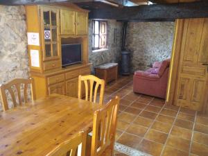 cocina y comedor con mesa y sofá en Casa El Carrelu, en Póo