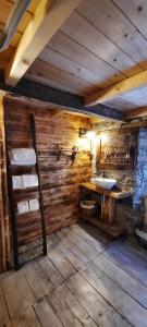 uma casa de banho com um lavatório e uma parede de madeira em b&b La Corte dei Cerri- Il Piccolo Chalet em Frassinoro