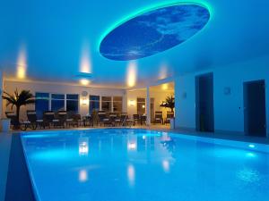 a swimming pool in a hotel with a blue light at Avalon Ferienwohnungen Bellevue in Fehmarn