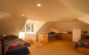 een zolderkamer met 2 bedden en een trap bij The White Cottage in Elgin