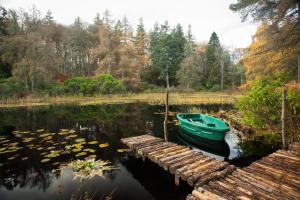 un bateau est amarré à côté d'un quai sur un lac dans l'établissement The White Cottage, à Elgin