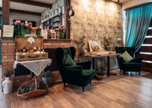 a room with chairs and a table and flowers at Dreko Panzió & Borbisztró in Győrújbarát