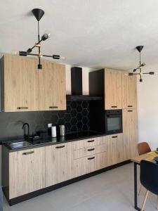 a kitchen with wooden cabinets and a black counter top at Sea View Apartment - first row to the beach in Zubovići