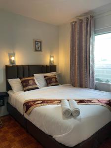 曼谷的住宿－Acozyposhtel，一间卧室配有一张大床和两条毛巾