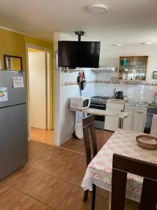 a kitchen with a table and a kitchen with a refrigerator at Bello Horizonte in El Quisco