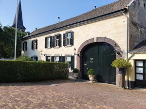 a large brick building with a green garage at Boutique Hotel Bonjour in Gronsveld
