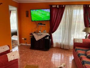 a living room with a flat screen tv on a wall at Bello Horizonte in El Quisco