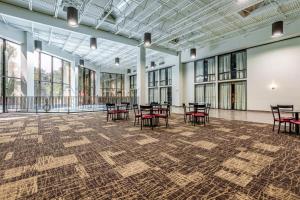 a large room with tables and chairs and windows at Red Roof Inn PLUS & Suites Houston - IAH Airport SW in Houston +28 photos