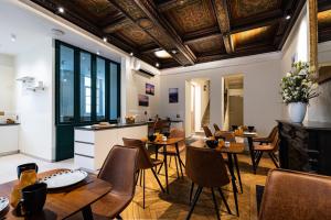 a restaurant with wooden tables and chairs and a ceiling at Hotel du Palais Dijon in Dijon