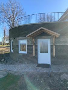 a brick house with a white door and two windows at Meerblick und Salz in der Luft in Fehmarn