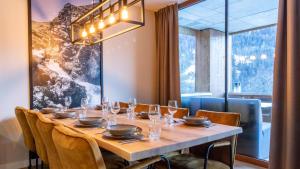 a dining room with a table and a large window at UplandParcs Silvretta in Schruns