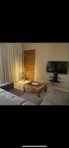 Una sala de estar con una mesa de café y un televisor de pantalla plana. en Spanish Water View Apartment C1, en Willemstad