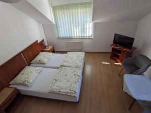 - une chambre avec un lit, une chaise et une télévision dans l'établissement Pokoje Gościnne - Leśna 8, à Ustronie Morskie