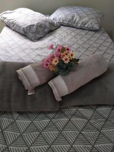 Una cama con una manta y un arreglo floral. en Casa Viva Bonito en Bonito