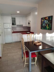 a kitchen with a dining room table and chairs at Playa Colina in Argoños